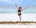 Athletic Amerasian girl dancing on the beach