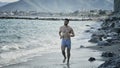 Young man exercising, jogging and running on beach Royalty Free Stock Photo