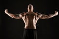 Athletic bald, bearded, tattooed man in black shorts is posing against a black background. Close-up portrait. Royalty Free Stock Photo