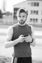 Athletic bearded man with muscular body holds cell phone