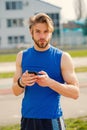 Athletic bearded man with muscular body holds cell phone