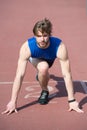 Athletic bearded man with muscular body stretching on running track Royalty Free Stock Photo