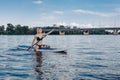 athletic beautiful girl paddle boarding