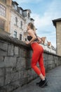 Athletic beautiful woman after a morning run admires the old city