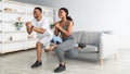 Athletic black couple doing lunges on home workout, copy space. Domestic training during covid lockdown Royalty Free Stock Photo