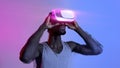 Athletic black guy wearing VR headset, doing virtual workout