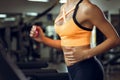 Athletic blond woman running on treadmill at gym.