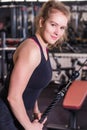 Athletic blonde woman in sportswear doing exercise on the triceps on the crossover machine in a gym Royalty Free Stock Photo