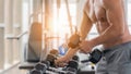 Athletic bodybuilder man lifting dumbbell from rack in gym and fitness club