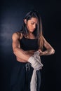 Athletic boxer female wraps bandages on her hands puts gloves for fight in gym. Workout, fitness concept