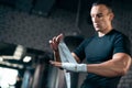 Athletic boxer man bandage hand and preparing for training or fighting in gym