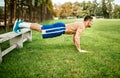 Athletic built man doing pushups and core training in park. Fitness basketball player training on grass Royalty Free Stock Photo