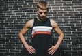 Athletic Caucasian man resting after fitness exercise. Sporty male standing against a brick wall. Sport, lifestyle, motivation and Royalty Free Stock Photo