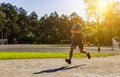 Athletic caucasian sportsman running fast under sunrays