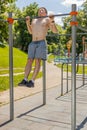 Athletic caucasian topless muscular man doing pull ups exercises on horizontal bar, pumping up back Royalty Free Stock Photo