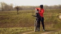 Athletic Caucasian woman eats protein bar ride on mountain bike on nature. Young sporty woman athlete in helmet resting while Royalty Free Stock Photo