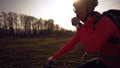 Athletic Caucasian woman eats protein bar ride on mountain bike on nature. Young sporty woman athlete in helmet resting while