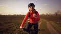 Athletic Caucasian woman eats protein bar ride on mountain bike on nature. Young sporty woman athlete in helmet resting while