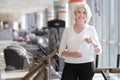 Athletic charming senior woman having rest during gym workout.