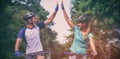 Athletic couple giving high five while riding bicycle on the road Royalty Free Stock Photo