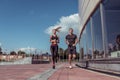 Athletic couple man woman, summer in city, jogging in jump, free space for text motivation fitness and workout Royalty Free Stock Photo