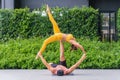 Athletic couple practicing acro yoga or yoga partner together in fitness park Royalty Free Stock Photo