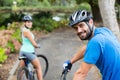 Athletic couple standing with mountain bike in forest Royalty Free Stock Photo