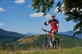 Athletic cyclist in sportswear and helmet cycling mountain bike, showing thumbs up, riding Royalty Free Stock Photo