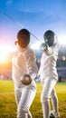Athletic fencers in protective masks and white uniforms engaged in a dynamic match under stadium lights. Royalty Free Stock Photo