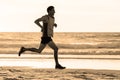 Athletic fit and strong runner man training on Summer sunset beach in sea shore running and fitness workout in sport and healthy l Royalty Free Stock Photo