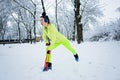 Athletic fitness woman doing exercise with resistance band on winter snowy park, forest background. Fitness woman Royalty Free Stock Photo