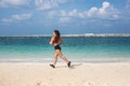 Athletic fitness woman running on the beach. Female runner jogging. Outdoor Workout Royalty Free Stock Photo