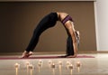 Athletic, flexible yoga woman in wheel pose indoors