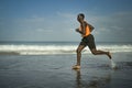Athletic full body portrait of young attractive and fit black African American man running on the beach doing Summer fitness Royalty Free Stock Photo
