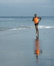 Athletic full body portrait of young attractive and fit black afro American man running on the beach doing Summer fitness jogging Royalty Free Stock Photo