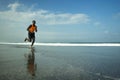 Athletic full body portrait of young attractive and fit black afro American man running on the beach doing Summer fitness jogging Royalty Free Stock Photo