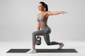 Athletic girl doing lunges exercises with kettlebell, leg muscle training. Fitness woman doing front forward one leg step lunge