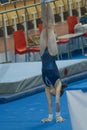 Athletic girl gymnast doing a handstand at the stadium