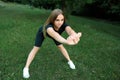 Athletic girl in the park does fitness, stretches and leans forward Royalty Free Stock Photo