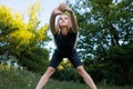 Athletic girl in the park does fitness, stretches and leans forward Royalty Free Stock Photo