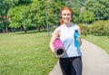 Athletic girl portrait starting or finishing outdoor workout in public park