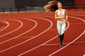 Athletic girl running at the stadium, working out, keep herself in shape, wearing sportswear, white top and pants Royalty Free Stock Photo