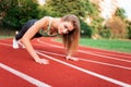 Athletic girl stands in the plank at the stadium runway.