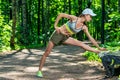 athletic girl warms up her muscles before jogging