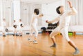 Athletic group practicing fencing techniques