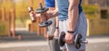 Athletic guy and girl doing exercises with dumbbells at the sports field Royalty Free Stock Photo