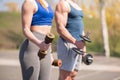 Athletic guy and girl doing exercises with dumbbells at the sports field Royalty Free Stock Photo