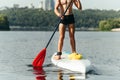 Athletic guy rowing on a sup board by the sea on a sunny day, frame photo. Active rest on a rowing board
