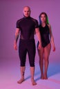 Athletic gymnasts in a black sport suits are posing in a studio.