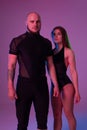 Athletic gymnasts in a black sport suits are posing in a studio.